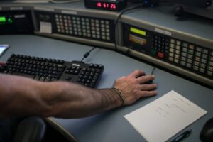 A large hand operates a transit radio system